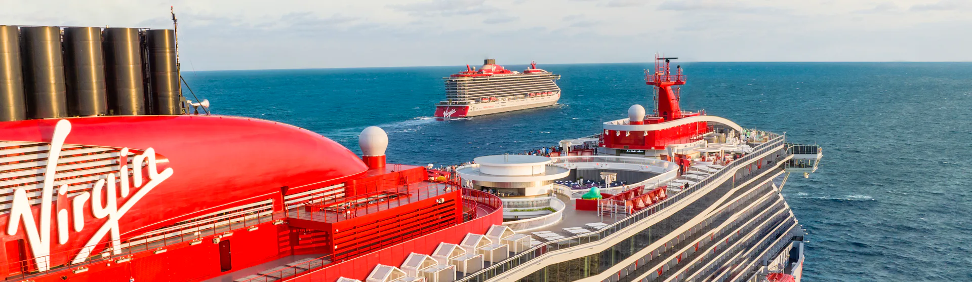 Two Virgin Voyages ships, Scarlet Lady and Valiant Lady, at sea