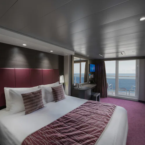 A balcony cabin room, with view of a bed, on MSC Grandiosa
