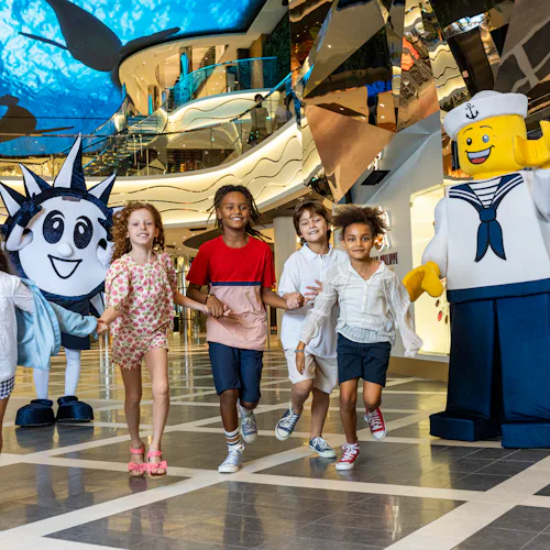 Group of kids onboard MSC with lego man and Doremi mascot