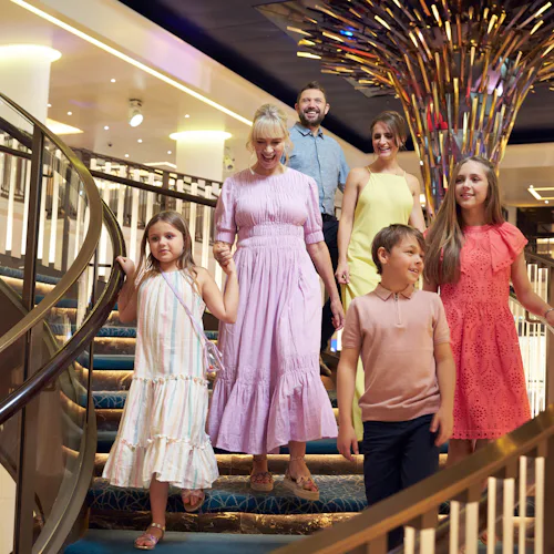 Family walking down atrium stairs on P&O ship