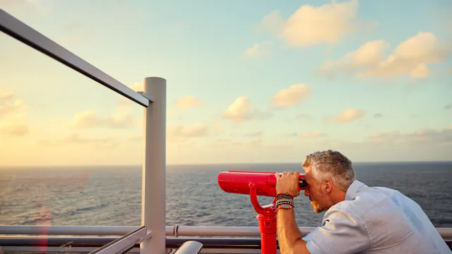 Man looking through telescope on Virgin Voyages ship